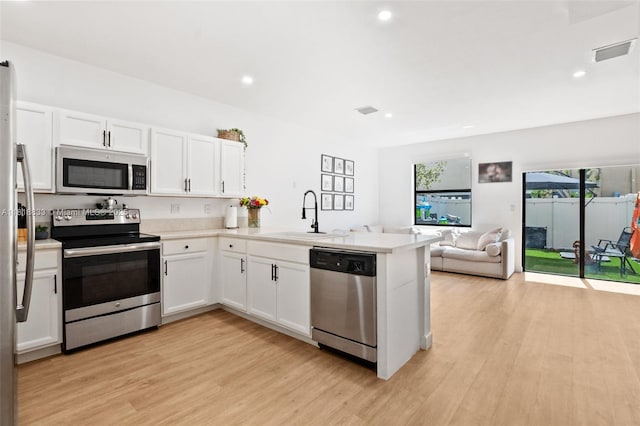 9362 W 33rd Ln, Hialeah, FL 33018 - kitchen with appliances with stainless steel finishes, a sink, a peninsula, light wood-style floors, and recessed lighting