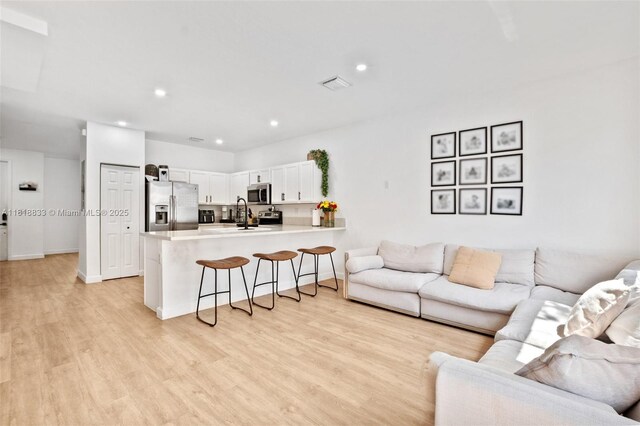 9362 W 33rd Ln, Hialeah, FL 33018 - living room with light wood-style flooring, recessed lighting, and baseboards