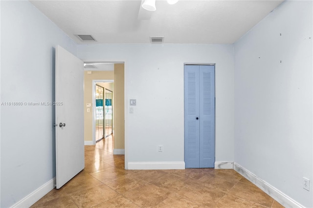 8663 Spring Valley Dr, Boynton Beach, FL 33472 - unfurnished bedroom with light tile patterned flooring, a closet, and baseboards