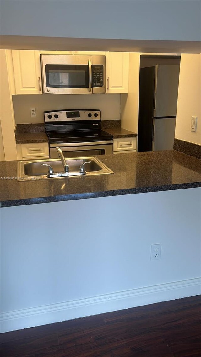 9808 Hammocks Blvd Unit 203-23, Miami, FL 33196 - kitchen with stainless steel appliances, white cabinets, dark wood-style flooring, and a peninsula