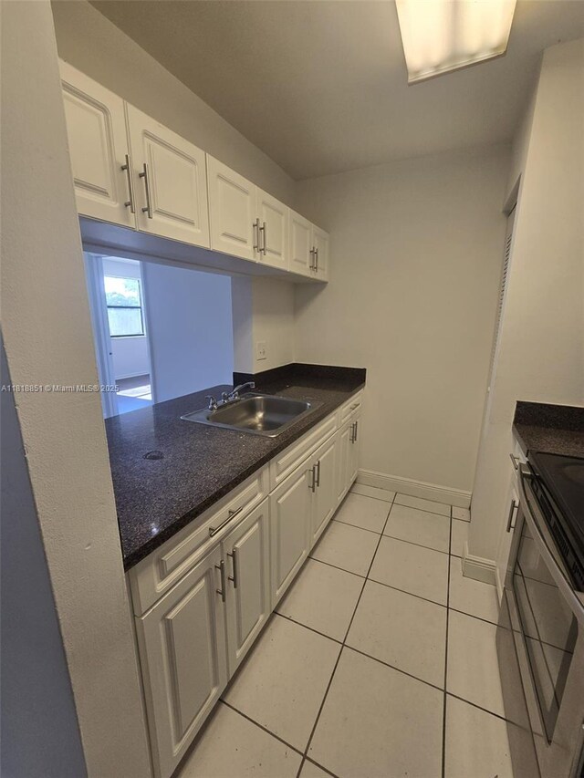 9808 Hammocks Blvd Unit 203-23, Miami, FL 33196 - kitchen with a sink, stainless steel range, white cabinetry, and light tile patterned floors