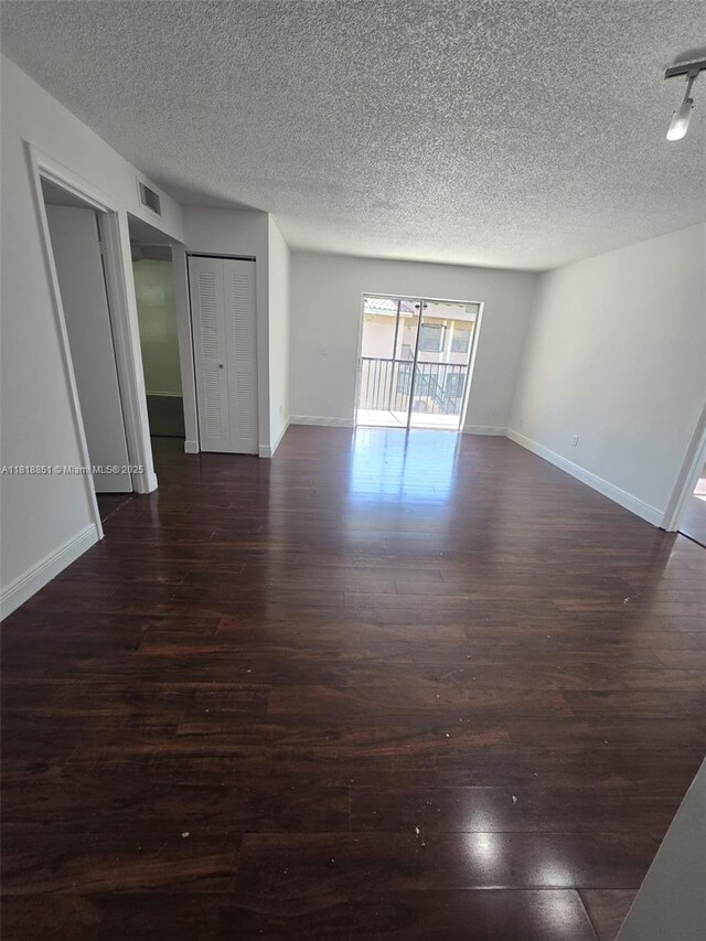 9808 Hammocks Blvd Unit 203-23, Miami, FL 33196 - unfurnished room with a textured ceiling, dark wood-style flooring, and baseboards