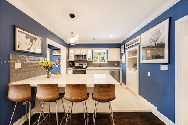 261 SW 30th Rd, Miami, FL 33129 - kitchen featuring appliances with stainless steel finishes, a sink, a peninsula, crown molding, and white cabinets
