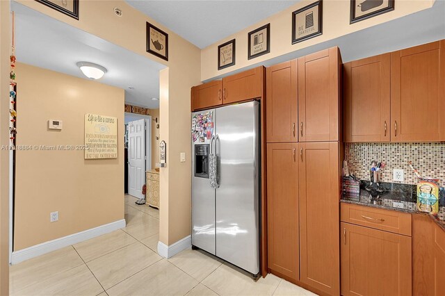 8440 SW 8th St Unit 306A, Miami, FL 33144 - kitchen featuring stainless steel fridge, tasteful backsplash, light tile patterned floors, baseboards, and dark stone countertops