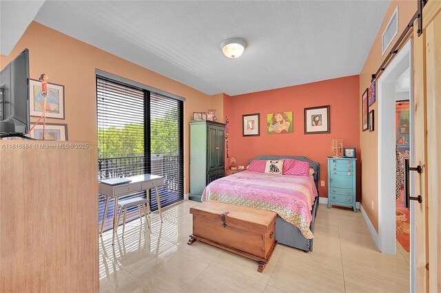 8440 SW 8th St Unit 306A, Miami, FL 33144 - bedroom featuring a barn door, light tile patterned floors, and a textured ceiling