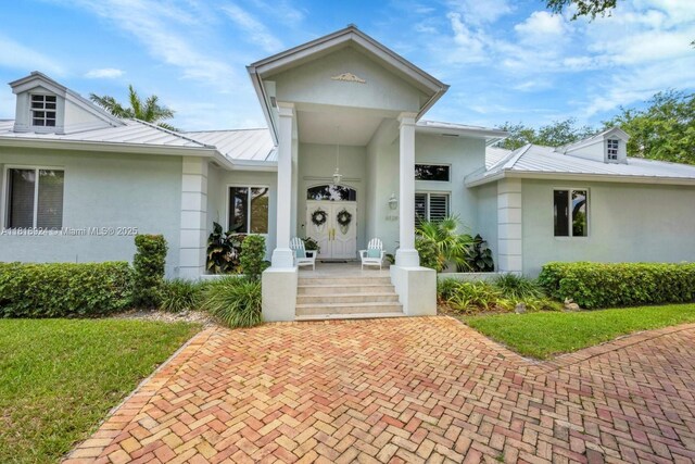 6129 SW 74th Ct, Miami, FL 33143 - view of front of property with a standing seam roof, stucco siding, a metal roof, and a front lawn