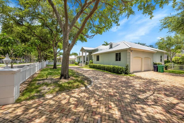 6129 SW 74th Ct, Miami, FL 33143 - view of home's exterior with an attached garage, stucco siding, a metal roof, and decorative driveway