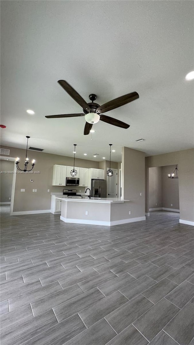 1115 Leader St, La Belle, FL 33935 - unfurnished living room featuring baseboards, a chandelier, a ceiling fan, and a sink