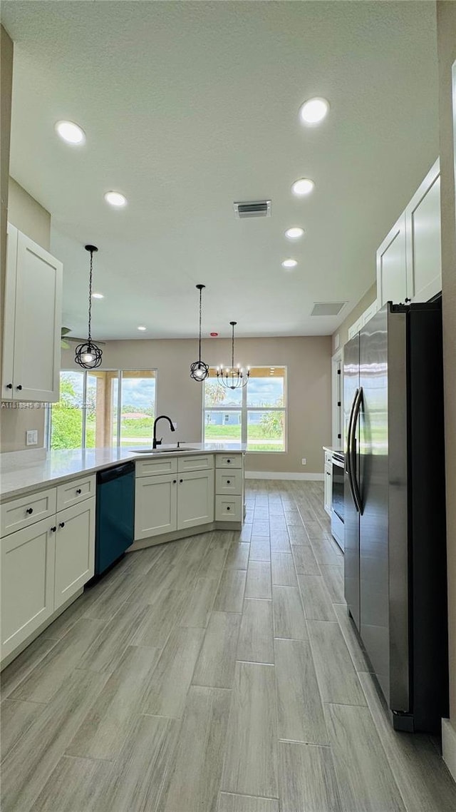 1115 Leader St, La Belle, FL 33935 - kitchen with stainless steel appliances, a sink, a peninsula, baseboards, and light wood-style flooring