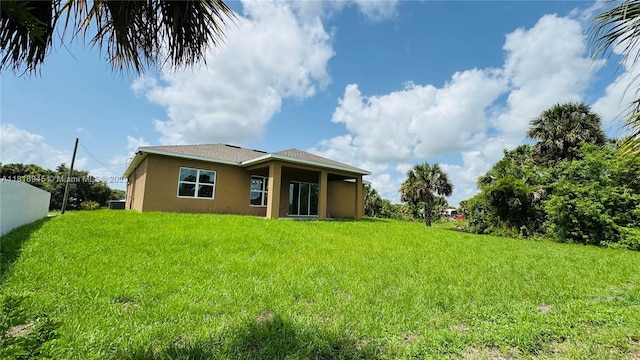 1115 Leader St, La Belle, FL 33935 - back of house featuring stucco siding and a lawn