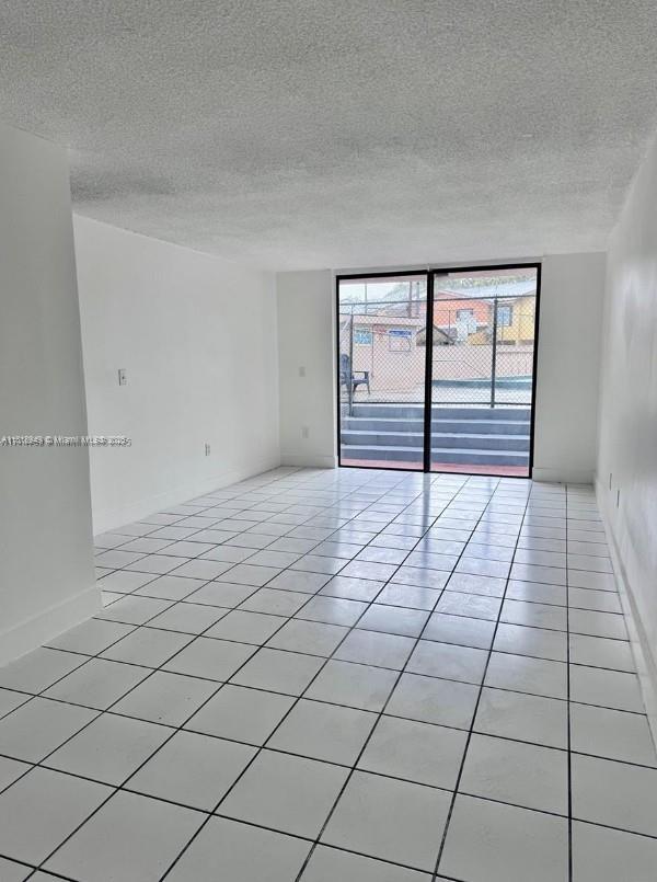 9678 Fontainebleau Blvd Unit 111, Miami, FL 33172 - spare room with light tile patterned floors and a textured ceiling
