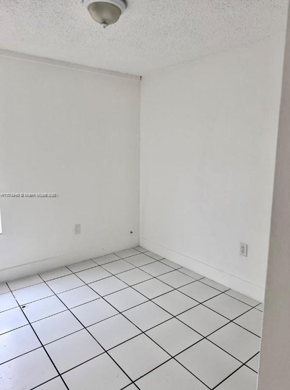 9678 Fontainebleau Blvd Unit 111, Miami, FL 33172 - empty room featuring a textured ceiling and light tile patterned flooring