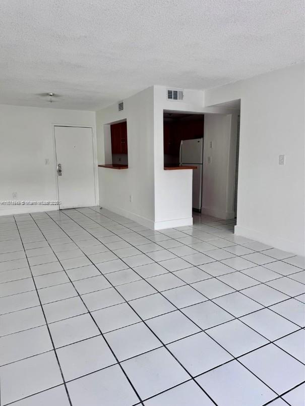 9678 Fontainebleau Blvd Unit 111, Miami, FL 33172 - spare room with a textured ceiling and light tile patterned flooring