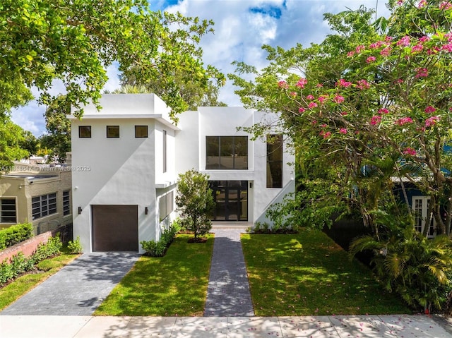 1513 SW 11th Ter, Miami, FL 33135 - contemporary home with an attached garage, stucco siding, a front lawn, and driveway