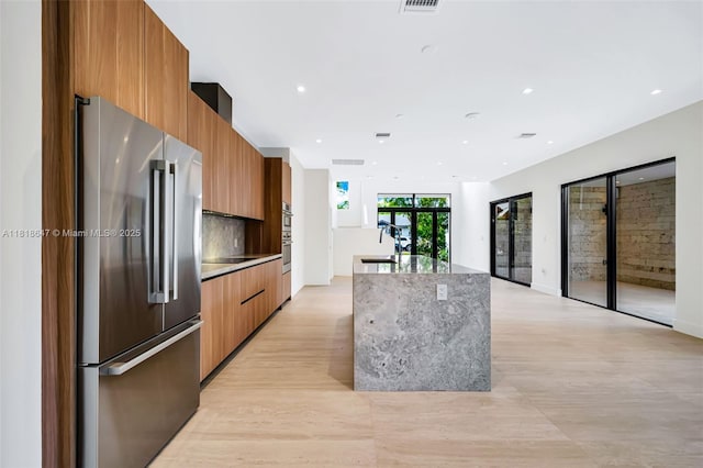 1513 SW 11th Ter, Miami, FL 33135 - kitchen with high end refrigerator, modern cabinets, brown cabinets, an island with sink, and tasteful backsplash