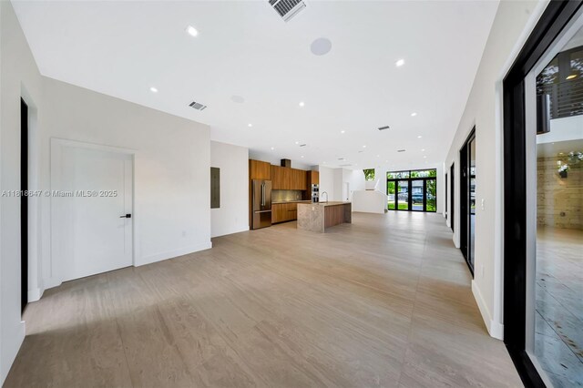 1513 SW 11th Ter, Miami, FL 33135 - unfurnished living room with a sink, recessed lighting, and light wood-style floors