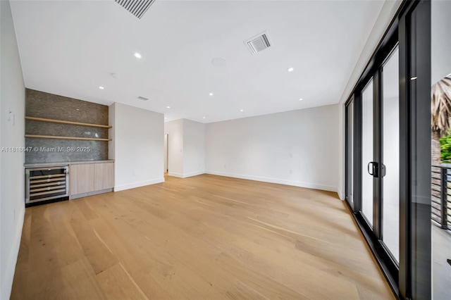 1513 SW 11th Ter, Miami, FL 33135 - unfurnished living room with wine cooler, light wood-style flooring, plenty of natural light, baseboards, and recessed lighting