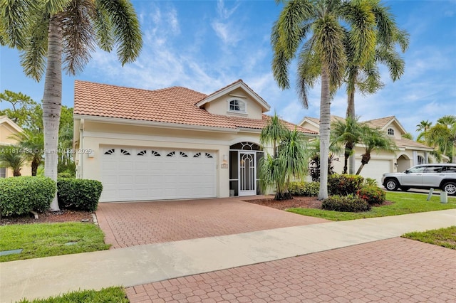 769 SW Munjack Cir, Port St Lucie, FL 34986 - mediterranean / spanish-style home with decorative driveway, stucco siding, an attached garage, and a tiled roof