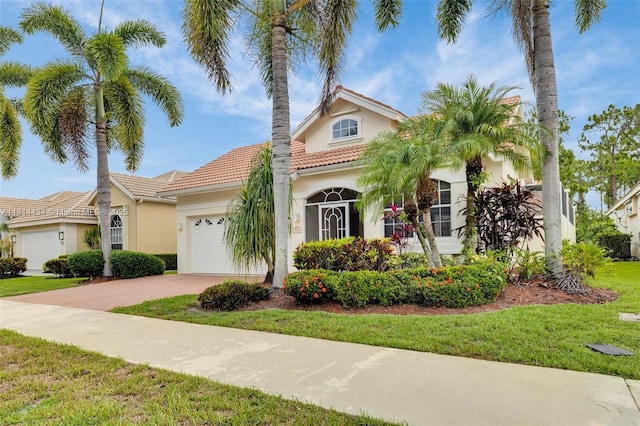 769 SW Munjack Cir, Port St Lucie, FL 34986 - mediterranean / spanish house with stucco siding, an attached garage, a tiled roof, and driveway
