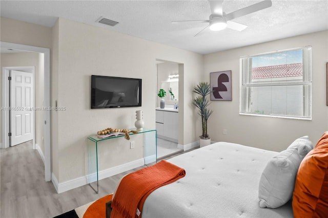 12633 NW 12th Ct, Sunrise, FL 33323 - bedroom with light wood finished floors, baseboards, a textured ceiling, ceiling fan, and ensuite bathroom