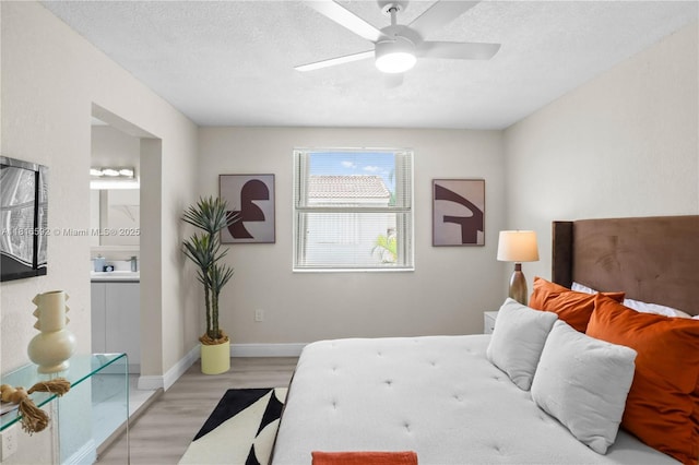 12633 NW 12th Ct, Sunrise, FL 33323 - bedroom featuring light wood finished floors, baseboards, ensuite bath, a textured ceiling, and ceiling fan