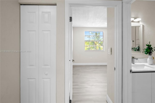 12633 NW 12th Ct, Sunrise, FL 33323 - hallway with wood finished floors, a sink, and baseboards