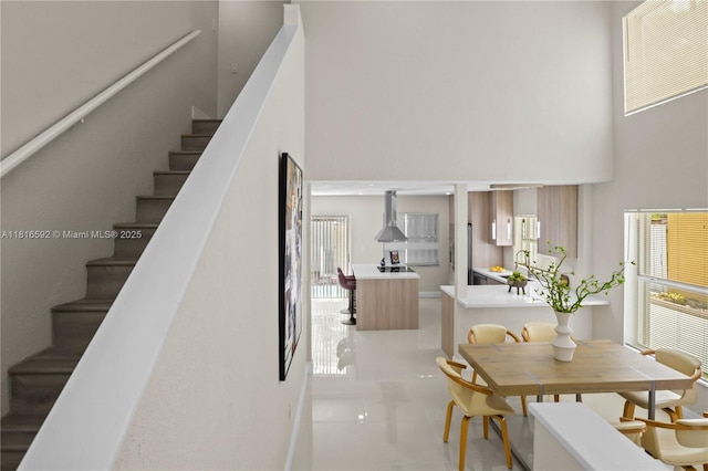 12633 NW 12th Ct, Sunrise, FL 33323 - dining room with a towering ceiling, stairs, and light tile patterned floors