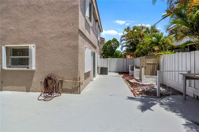 12633 NW 12th Ct, Sunrise, FL 33323 - view of side of home with stucco siding, a patio, a fenced backyard, and cooling unit