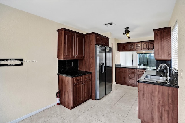 9601 NW 8th Cir, Plantation, FL 33324 - kitchen featuring stainless steel fridge with ice dispenser, a sink, dark countertops, decorative backsplash, and light tile patterned floors