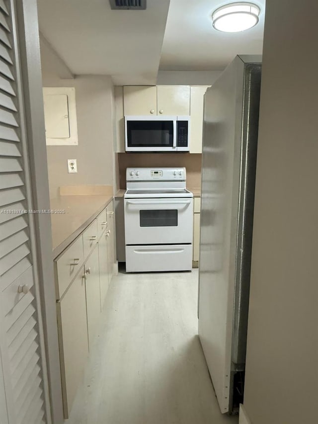 870 NW 87th Ave Unit 310, Miami, FL 33172 - kitchen featuring white appliances, white cabinets, light countertops, and light wood finished floors