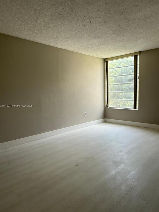 870 NW 87th Ave Unit 310, Miami, FL 33172 - spare room featuring wood finished floors, baseboards, and a textured ceiling