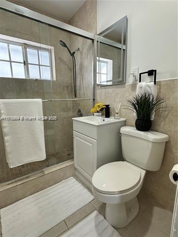 280 NE 169th St, North Miami Beach, FL 33162 - bathroom with a shower stall, vanity, tile walls, and tile patterned floors