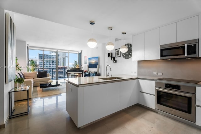 68 SE 6th St Unit 1704, Miami, FL 33131 - kitchen with appliances with stainless steel finishes, a sink, a peninsula, expansive windows, and modern cabinets