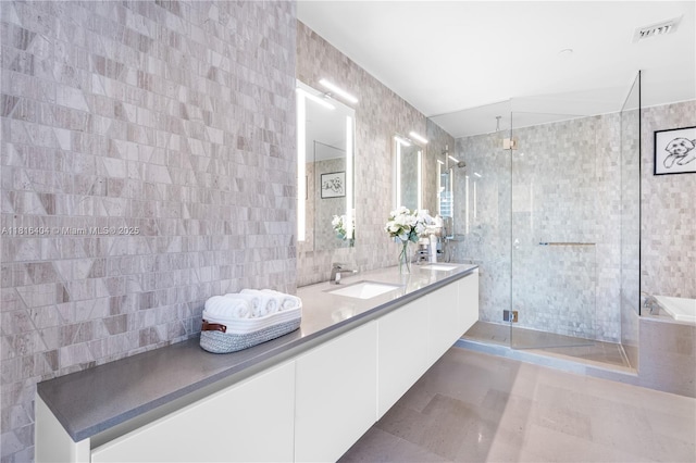 68 SE 6th St Unit 1704, Miami, FL 33131 - full bath featuring tile walls, a stall shower, double vanity, tile patterned flooring, and a bath