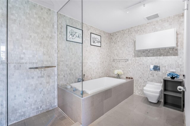 68 SE 6th St Unit 1704, Miami, FL 33131 - bathroom with tile walls, toilet, tile patterned flooring, and a bath