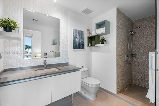 68 SE 6th St Unit 1704, Miami, FL 33131 - full bathroom with toilet, a tile shower, vanity, tile patterned flooring, and decorative backsplash