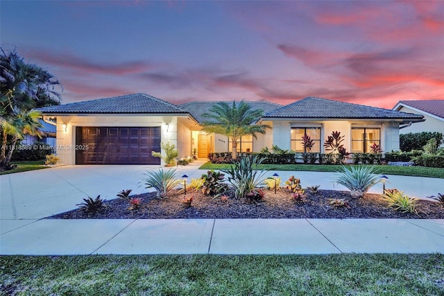 18366 Lake Bend Dr, Jupiter, FL 33458 - view of front facade with a tile roof, stucco siding, and a garage