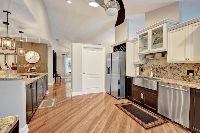 18366 Lake Bend Dr, Jupiter, FL 33458 - kitchen featuring appliances with stainless steel finishes, backsplash, light wood-style floors, glass insert cabinets, and hanging light fixtures