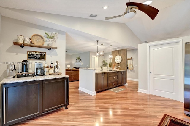 18366 Lake Bend Dr, Jupiter, FL 33458 - kitchen featuring light wood-style floors, a ceiling fan, lofted ceiling, light stone countertops, and dark brown cabinets