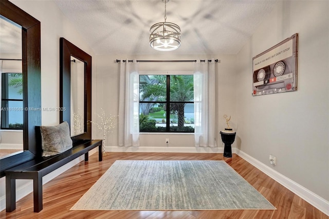 18366 Lake Bend Dr, Jupiter, FL 33458 - sitting room featuring a chandelier, vaulted ceiling, wood finished floors, and a textured ceiling