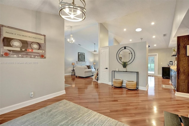 18366 Lake Bend Dr, Jupiter, FL 33458 - living area with a chandelier, vaulted ceiling, light wood-style floors, and recessed lighting