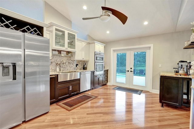18366 Lake Bend Dr, Jupiter, FL 33458 - kitchen featuring appliances with stainless steel finishes, a ceiling fan, light stone countertops, tasteful backsplash, and light wood-type flooring