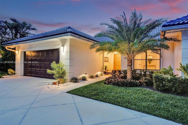 18366 Lake Bend Dr, Jupiter, FL 33458 - view of front of home featuring an attached garage, driveway, a tile roof, and stucco siding
