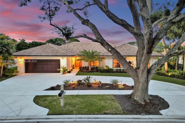 18366 Lake Bend Dr, Jupiter, FL 33458 - mediterranean / spanish-style home with stucco siding, a tile roof, an attached garage, a lawn, and concrete driveway