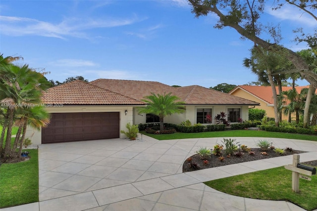 18366 Lake Bend Dr, Jupiter, FL 33458 - mediterranean / spanish home featuring curved driveway, stucco siding, a tiled roof, an attached garage, and a front yard