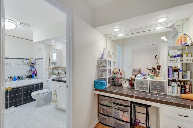 1057 NE 202nd Ln, Miami, FL 33179 - bathroom featuring a garden tub, vanity, toilet, and tile patterned flooring