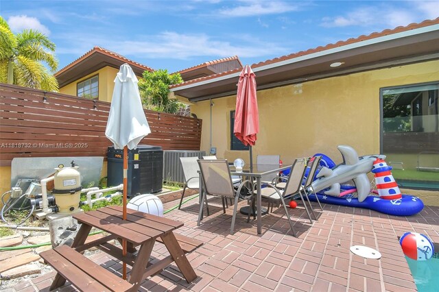 1057 NE 202nd Ln, Miami, FL 33179 - view of patio / terrace featuring outdoor dining space and central AC unit