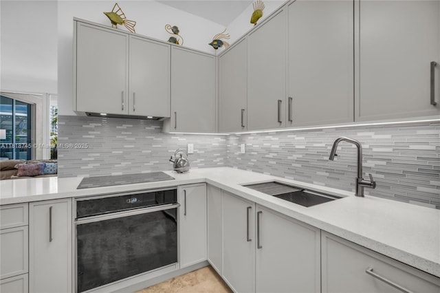 400 Alton Rd Unit 407, Miami Beach, FL 33139 - kitchen featuring black appliances, decorative backsplash, light countertops, and under cabinet range hood