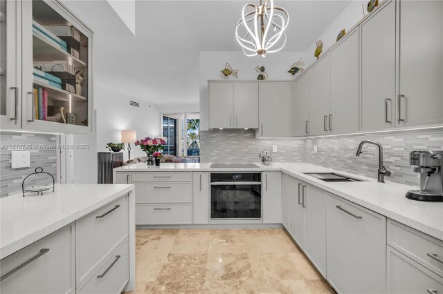 400 Alton Rd Unit 407, Miami Beach, FL 33139 - kitchen featuring black appliances, decorative backsplash, pendant lighting, a chandelier, and a peninsula