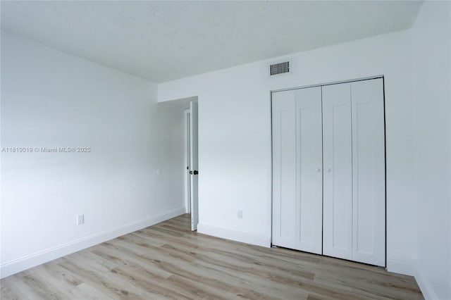 5501 NW 7th St Unit E408, Miami, FL 33126 - unfurnished bedroom with wood finished floors, baseboards, and a closet
